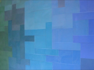 mosaico hidráulico de vários tons de azuis e verdes em  formatos diversos aplicado numa tampa de uma mesa. O design é da Mette Laerke da Projecto Mosaico