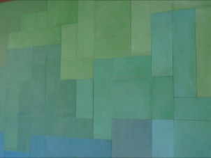 mosaico hidráulico de vários tons de azuis e verdes em  formatos diversos aplicado numa tampa de uma mesa. O design é da Mette Laerke da Projecto Mosaico