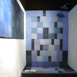 Mosaicos hidráulicos monocromáticos de vários tamanhos na parede e pavimento num chuveiro projectada pelo atelier Comterra Lda.